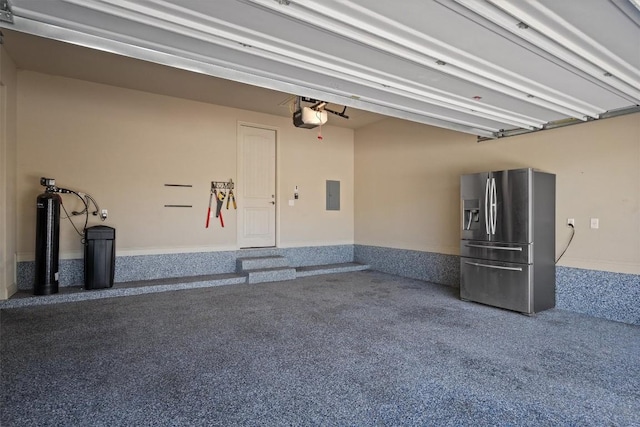 413 Fair Oaks Dr, Georgetown, TX 78628 - garage featuring stainless steel fridge with ice dispenser, a garage door opener, and electric panel