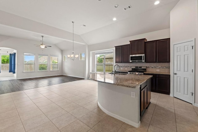 6042 Roma St, Round Rock, TX 78665 - kitchen with appliances with stainless steel finishes, light tile patterned flooring, vaulted ceiling, a chandelier, and tasteful backsplash