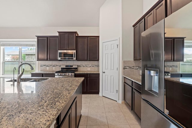 6042 Roma St, Round Rock, TX 78665 - kitchen featuring stainless steel appliances, tasteful backsplash, light stone counters, and dark brown cabinets