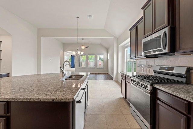 6042 Roma St, Round Rock, TX 78665 - kitchen featuring stainless steel appliances, dark brown cabinets, decorative backsplash, a chandelier, and vaulted ceiling
