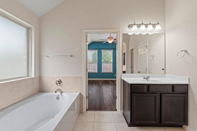 6042 Roma St, Round Rock, TX 78665 - bathroom featuring lofted ceiling, vanity, a bath, tile patterned floors, and a ceiling fan