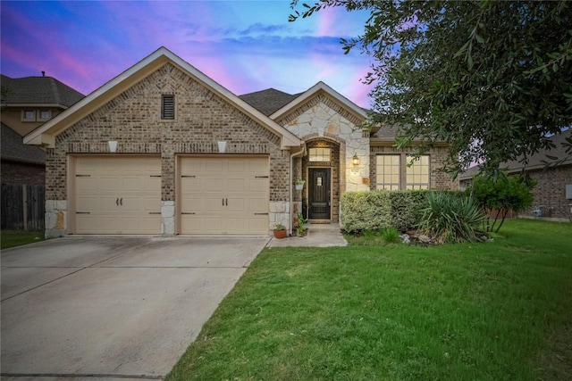 6042 Roma St, Round Rock, TX 78665 - french country home featuring an attached garage, stone siding, driveway, brick siding, and a lawn