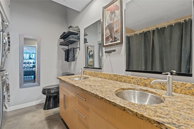 2124 E 6th St Unit 319, Austin, TX 78702 - full bathroom with estacked washer and dryer, double vanity, finished concrete floors, and a shower with curtain