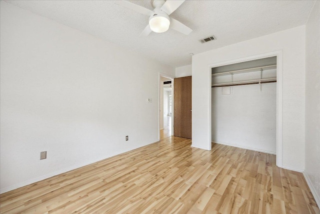 4910 Wing Rd, Austin, TX 78749 - unfurnished bedroom with light wood-style floors, a closet, a ceiling fan, and a textured ceiling