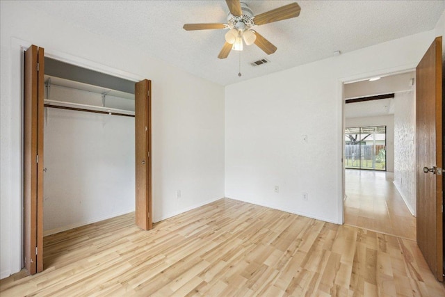 4910 Wing Rd, Austin, TX 78749 - unfurnished bedroom featuring light wood-type flooring, a textured ceiling, a closet, and a ceiling fan