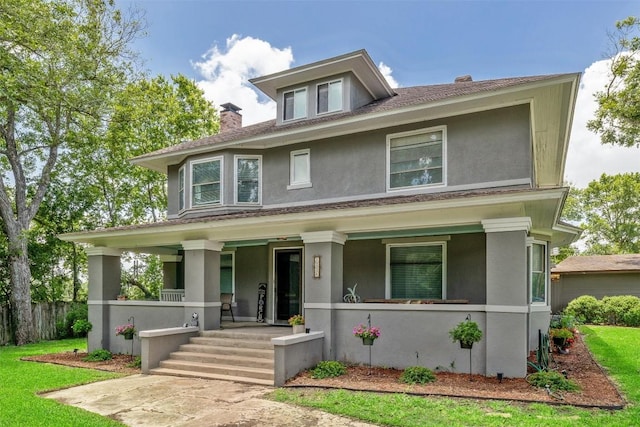 1004 Mitchell St, Gonzales, TX 78629 - traditional style home featuring a porch, stucco siding, a chimney, and a shingled roof