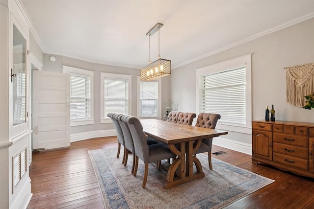 1004 Mitchell St, Gonzales, TX 78629 - dining space with dark wood-type flooring, a chandelier, and ornamental molding