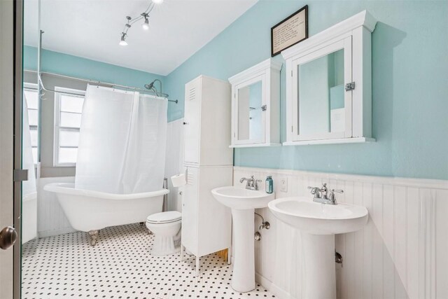 1004 Mitchell St, Gonzales, TX 78629 - full bathroom with a freestanding bath, a wainscoted wall, and curtained shower