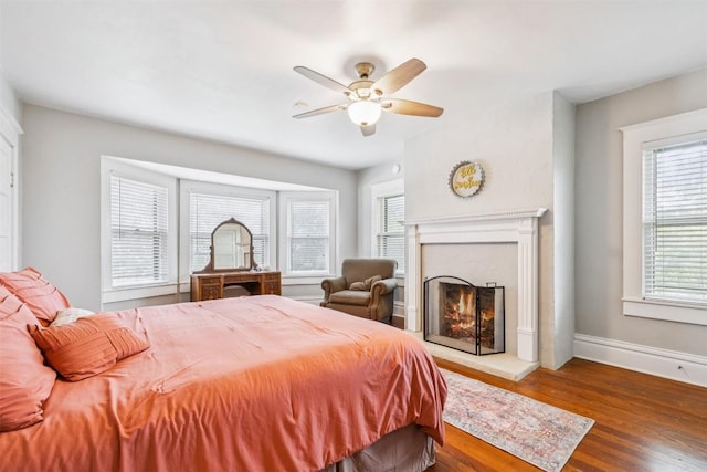 1004 Mitchell St, Gonzales, TX 78629 - bedroom with wood finished floors, a fireplace, and ceiling fan