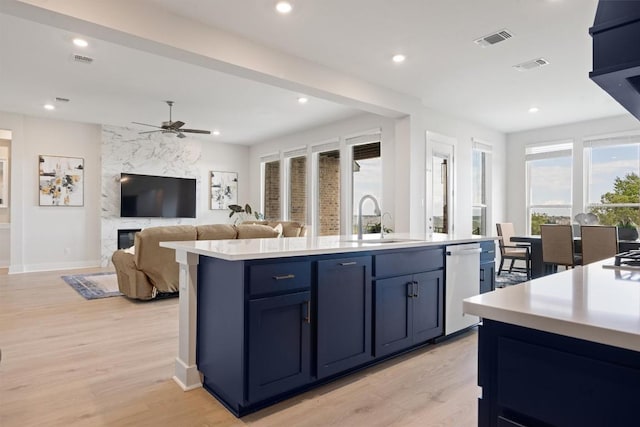 2233 Bellisa Vista Dr, Leander, TX 78641 - kitchen with white dishwasher, light countertops, light wood finished floors, a kitchen island with sink, and recessed lighting