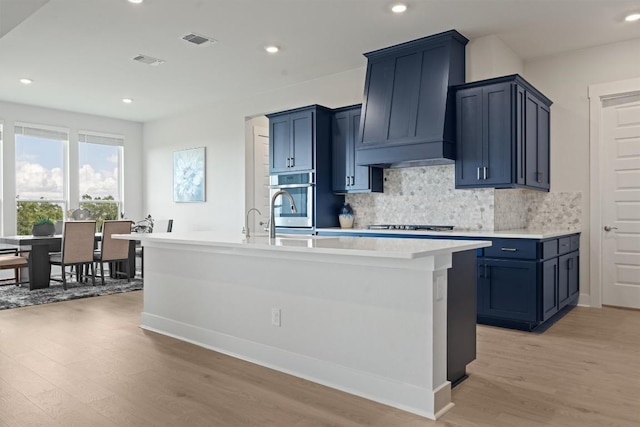 2233 Bellisa Vista Dr, Leander, TX 78641 - kitchen featuring light wood-style flooring, appliances with stainless steel finishes, backsplash, light countertops, and recessed lighting