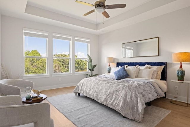 2233 Bellisa Vista Dr, Leander, TX 78641 - bedroom featuring wood finished floors, a tray ceiling, and ceiling fan