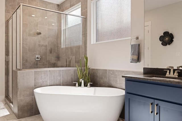 2233 Bellisa Vista Dr, Leander, TX 78641 - full bathroom featuring a soaking tub, a shower stall, vanity, tile walls, and marble look tiles