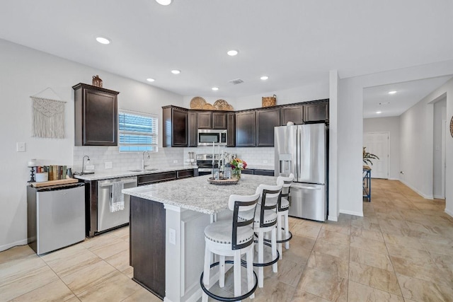 717 Friars Tuck Dr, Temple, TX 76502 - kitchen with appliances with stainless steel finishes, dark brown cabinetry, backsplash, a kitchen island, and recessed lighting