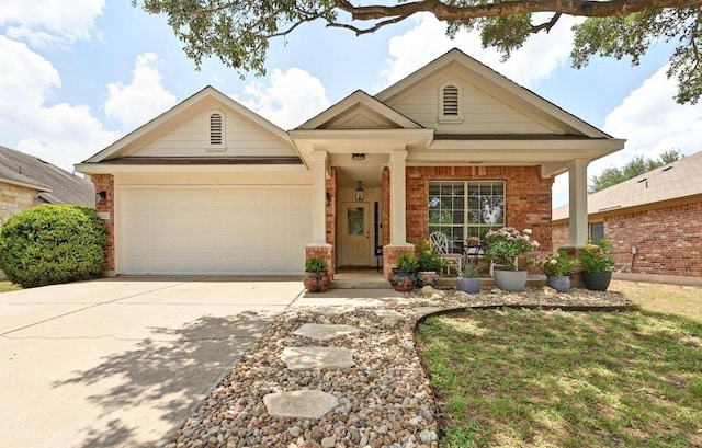 12112 Rancho Alto Rd, Austin, TX 78748 - view of front facade with a garage, concrete driveway, brick siding, and covered porch