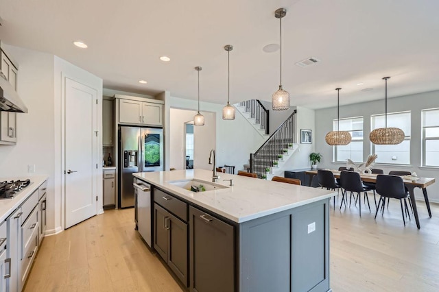 1209 Brasano Pl, Leander, TX 78641 - kitchen featuring light wood-style flooring, stainless steel appliances, a center island with sink, recessed lighting, and decorative light fixtures