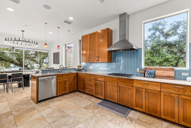 1417 Osprey Ridge Loop, Lago Vista, TX 78645 - kitchen with wall chimney range hood, stainless steel appliances, brown cabinets, tasteful backsplash, and a peninsula