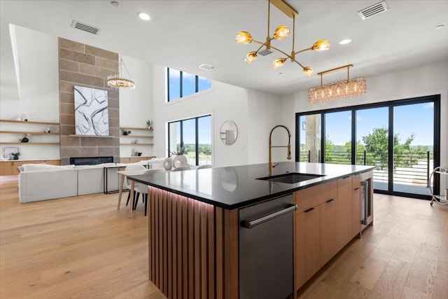 1000 Southlake Ranch Rd, Georgetown, TX 78628 - kitchen with a chandelier, light wood finished floors, open floor plan, dark countertops, and an island with sink