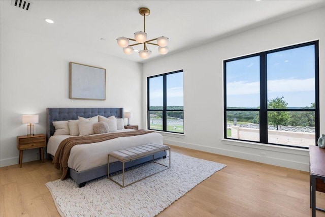 1000 Southlake Ranch Rd, Georgetown, TX 78628 - bedroom with light wood finished floors, a chandelier, and recessed lighting