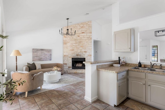 905 Minturn Ln, Austin, TX 78748 - kitchen featuring open floor plan, a peninsula, a fireplace, high vaulted ceiling, and hanging light fixtures