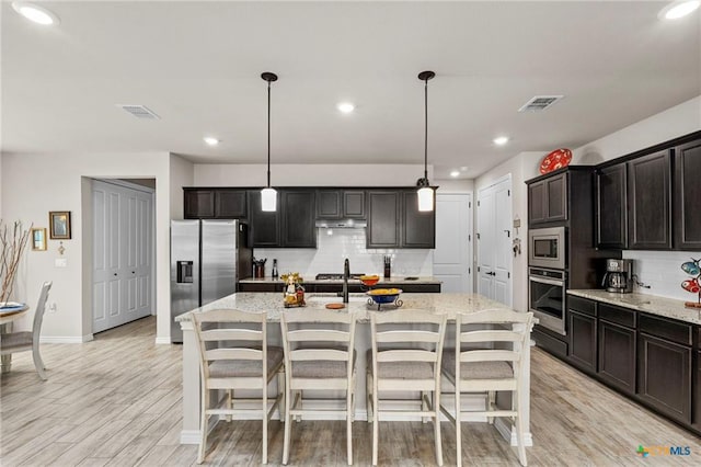 220 Bolivar Way Unit 101, San Marcos, TX 78666 - kitchen featuring stainless steel appliances, decorative backsplash, light stone countertops, and recessed lighting