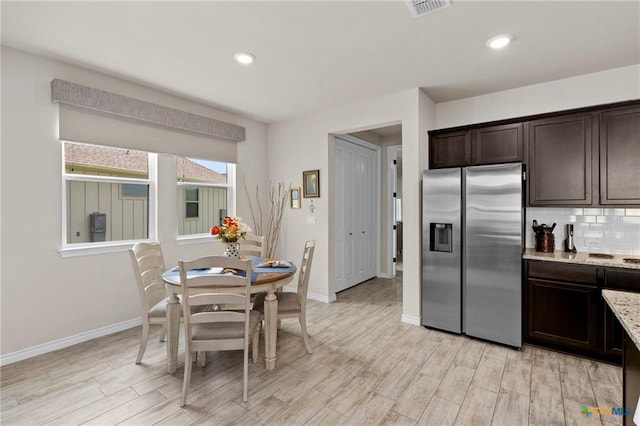 220 Bolivar Way Unit 101, San Marcos, TX 78666 - kitchen featuring stainless steel fridge, dark brown cabinets, light wood-style floors, decorative backsplash, and light stone counters