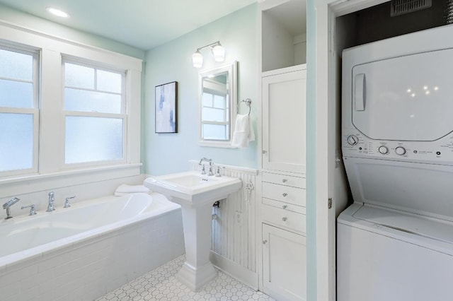 4410 Sinclair Ave, Austin, TX 78756 - full bathroom featuring stacked washing machine and dryer, a bath, and tile patterned floors