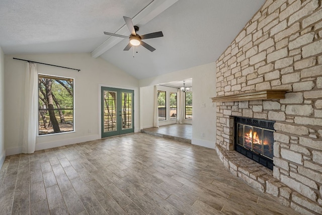216 Country Rd, Georgetown, TX 78628 - unfurnished living room with a stone fireplace, a ceiling fan, wood finished floors, and a chandelier