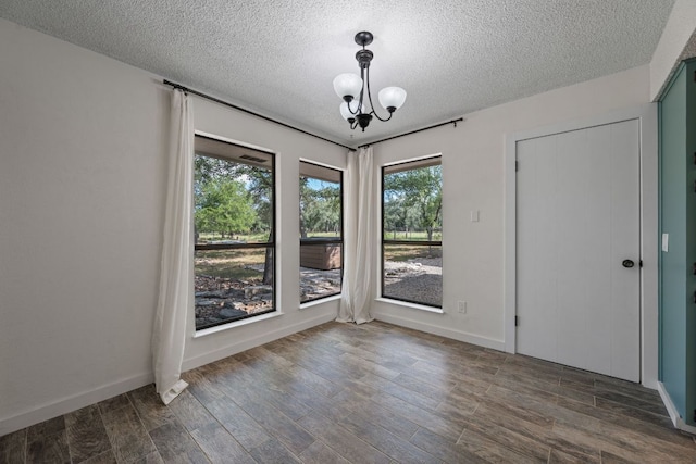 216 Country Rd, Georgetown, TX 78628 - unfurnished dining area featuring a textured ceiling, dark wood-style flooring, and a chandelier