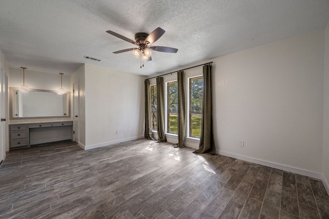 216 Country Rd, Georgetown, TX 78628 - unfurnished room with a ceiling fan, a textured ceiling, dark wood finished floors, and a desk