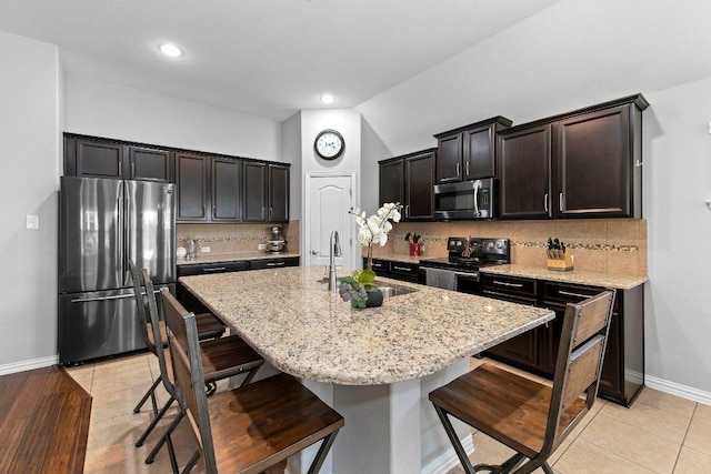 1008 Tabernash Dr, Leander, TX 78641 - kitchen with appliances with stainless steel finishes, a kitchen breakfast bar, light stone countertops, and recessed lighting