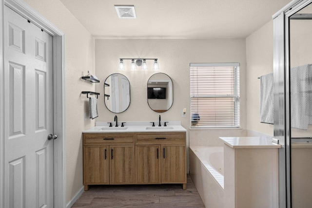 203 Ponderosa Dr, Harker Heights, TX 76548 - bathroom with double vanity, a garden tub, and wood finished floors
