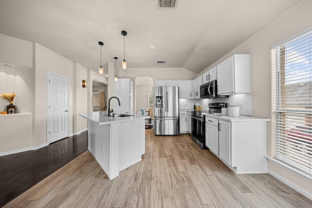 203 Ponderosa Dr, Harker Heights, TX 76548 - kitchen with stainless steel appliances, light wood-type flooring, arched walkways, light countertops, and lofted ceiling