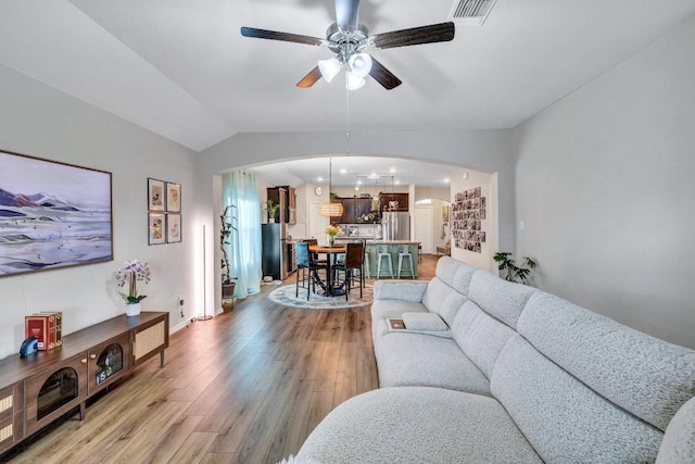 1904 T H Johnson Dr, Taylor, TX 76574 - living room featuring arched walkways, a ceiling fan, light wood-style floors, lofted ceiling, and recessed lighting