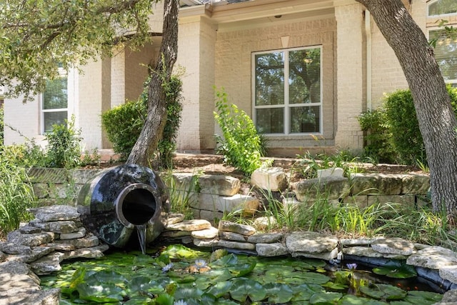 9601 Billingham Trl, Austin, TX 78717 - entrance to property featuring a small pond and brick siding