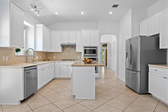9601 Billingham Trl, Austin, TX 78717 - kitchen with stainless steel appliances, arched walkways, under cabinet range hood, backsplash, and white cabinets