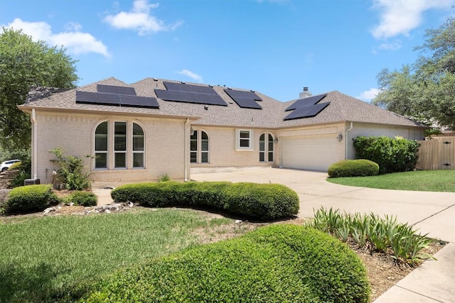 9601 Billingham Trl, Austin, TX 78717 - rear view of house with brick siding, a shingled roof, an attached garage, and roof mounted solar panels