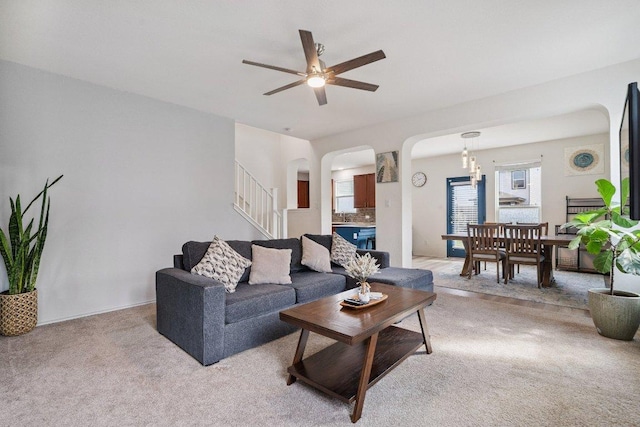 13821 Benjamin Harrison St, Manor, TX 78653 - living area featuring arched walkways, light colored carpet, stairs, and ceiling fan