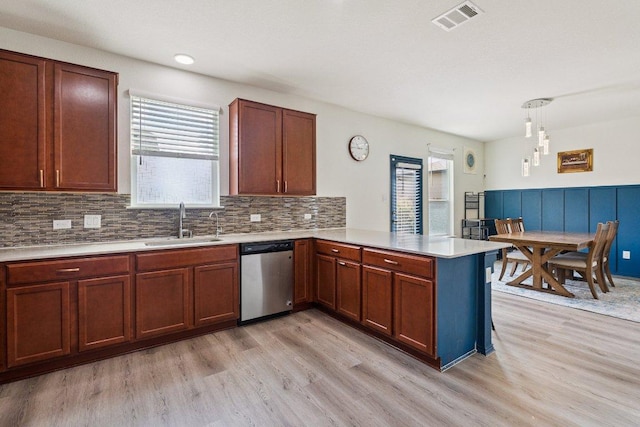 13821 Benjamin Harrison St, Manor, TX 78653 - kitchen featuring stainless steel dishwasher, a peninsula, healthy amount of natural light, light wood finished floors, and wainscoting