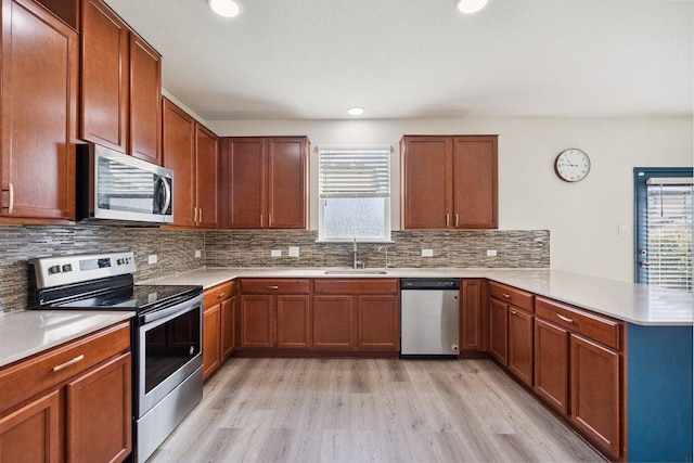 13821 Benjamin Harrison St, Manor, TX 78653 - kitchen with stainless steel appliances, a peninsula, plenty of natural light, light wood-style flooring, and recessed lighting