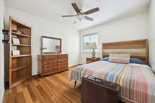 9902 Marseilles Dr, Austin, TX 78750 - bedroom with wood finished floors, a textured ceiling, and a ceiling fan