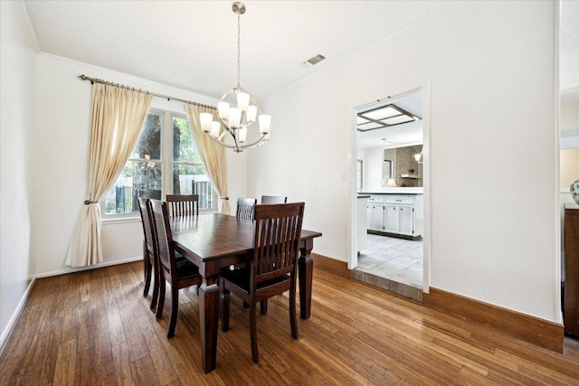 9902 Marseilles Dr, Austin, TX 78750 - dining area featuring a chandelier, wood-type flooring, and ornamental molding