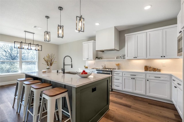 1720 Cannon St, Gonzales, TX 78629 - kitchen with stainless steel electric range, an island with sink, dark wood-style floors, white cabinets, and recessed lighting