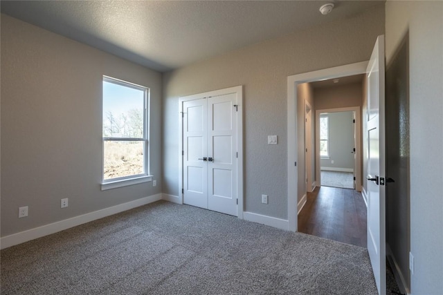 1720 Cannon St, Gonzales, TX 78629 - unfurnished bedroom with multiple windows, carpet flooring, a closet, and a textured ceiling