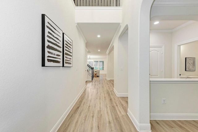 7517 Knockfin Dr, Austin, TX 78744 - hallway with crown molding, wood finished floors, arched walkways, stairway, and recessed lighting