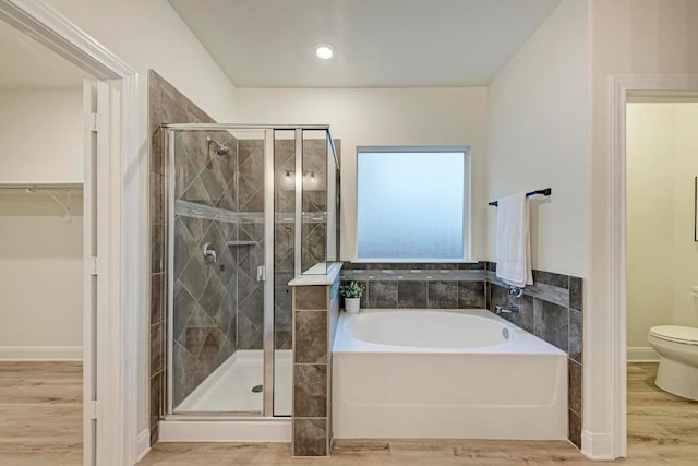 7517 Knockfin Dr, Austin, TX 78744 - bathroom with a bath, a stall shower, wood finished floors, and a walk in closet