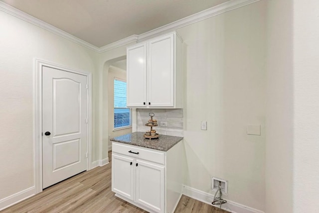 7517 Knockfin Dr, Austin, TX 78744 - washroom with ornamental molding, light wood-style floors, and arched walkways