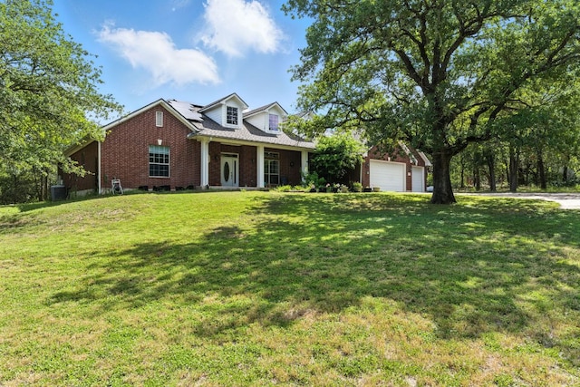 230 Hoffman Rd, Bastrop, TX 78602 - cape cod-style house featuring brick siding, a front yard, roof mounted solar panels, and a detached garage