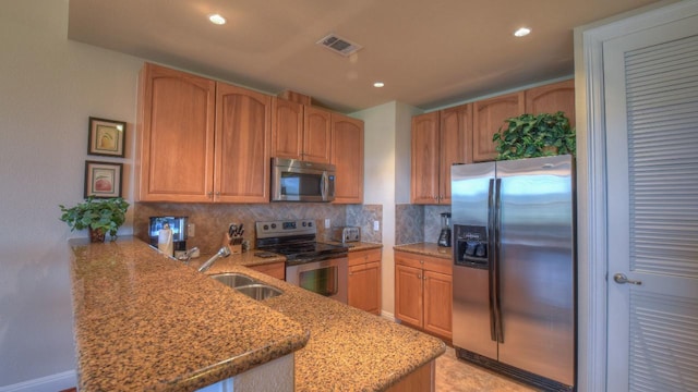 101 W Bank Unit 51, Horseshoe Bay, TX 78657 - kitchen with appliances with stainless steel finishes, a peninsula, light stone counters, tasteful backsplash, and recessed lighting