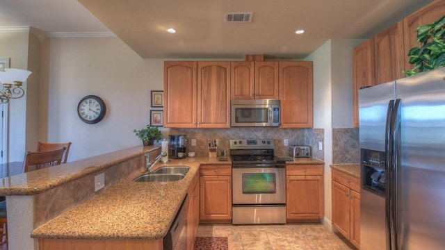 101 W Bank Unit 51, Horseshoe Bay, TX 78657 - kitchen with stainless steel appliances, a peninsula, tasteful backsplash, light stone counters, and ornamental molding